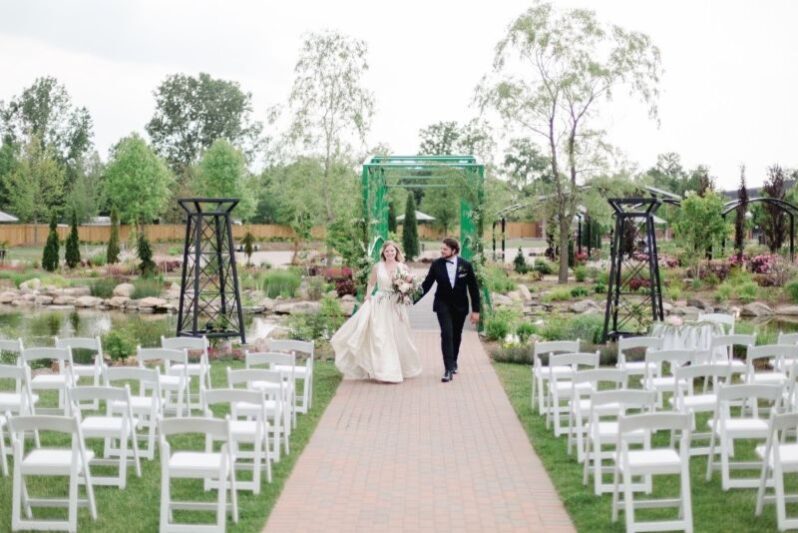 A couple walking down the aisle at The Gardens, an outdoor wedding venue in Niagara on the Lake