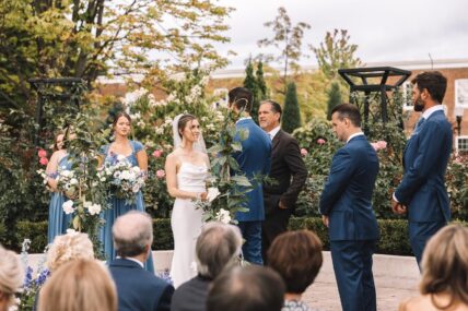 A couple getting married in The Gardens at Pillar and Post surrounded by flowers.