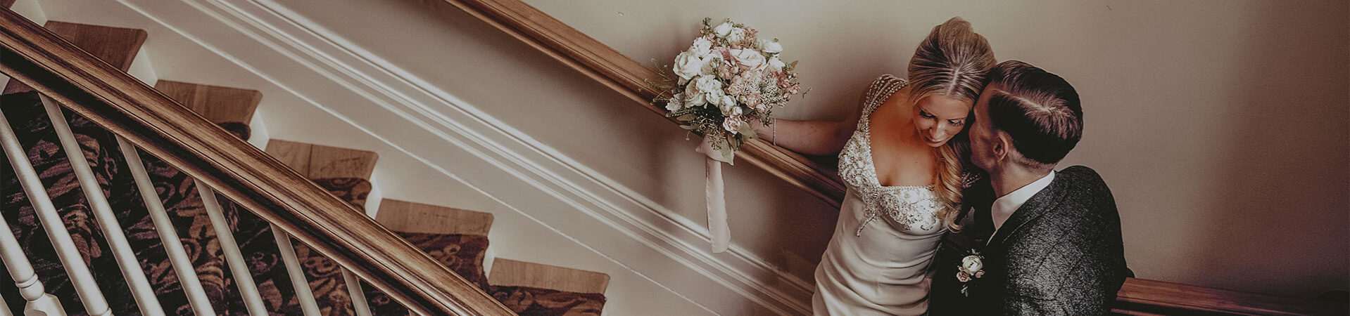 Newlyweds sharing a private moment on the staircase at the Queens Landing Hotel in Niagara-on-the-Lake