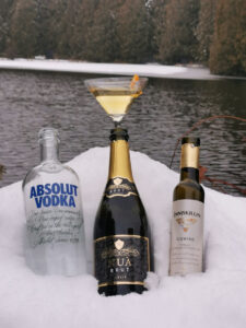 Bottles of alcohol on ice with an Icewine Kiss cocktail behind them.