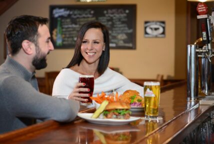 A couple enjoying pub fare at Jordan House Tavern in the Niagara Benchlands.