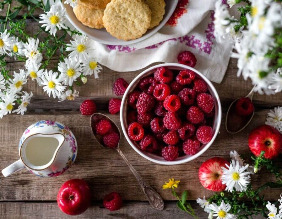 A bowl or raspberries being used for Vintage Hotel's Raspberry Lemonade Cookies.