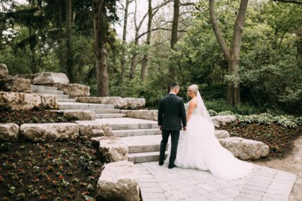 A couple standing on the stone staircase near the Water View Garden at the Queen’s Landing hotel.