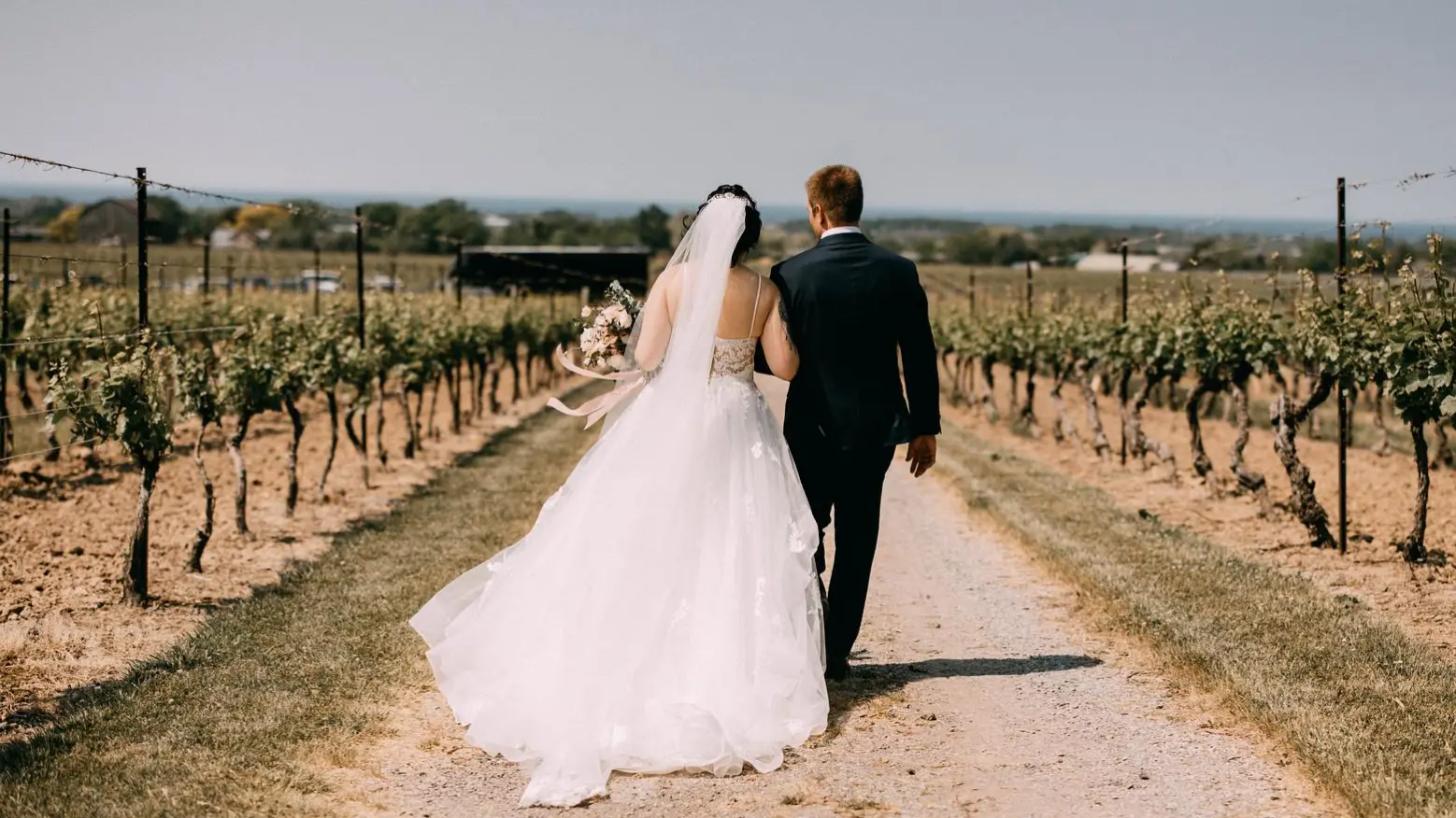 A couple walking through a stunning vineyard wedding venue near Toronto.